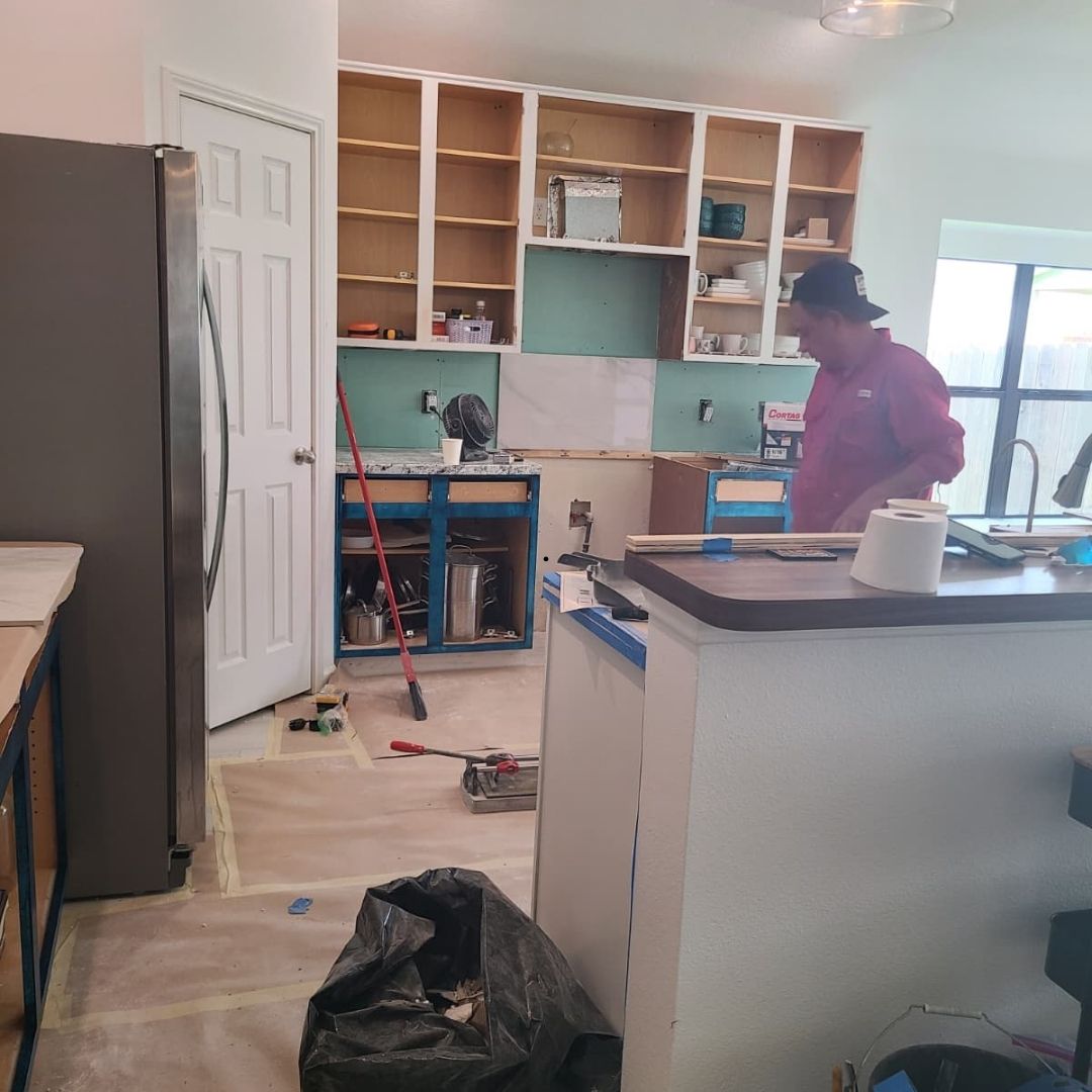 During kitchen remodel in Houston with cabinets open and surfaces protected